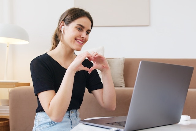 Mujer feliz trabajando en un ordenador, marca empleadora Marcas que enamoran